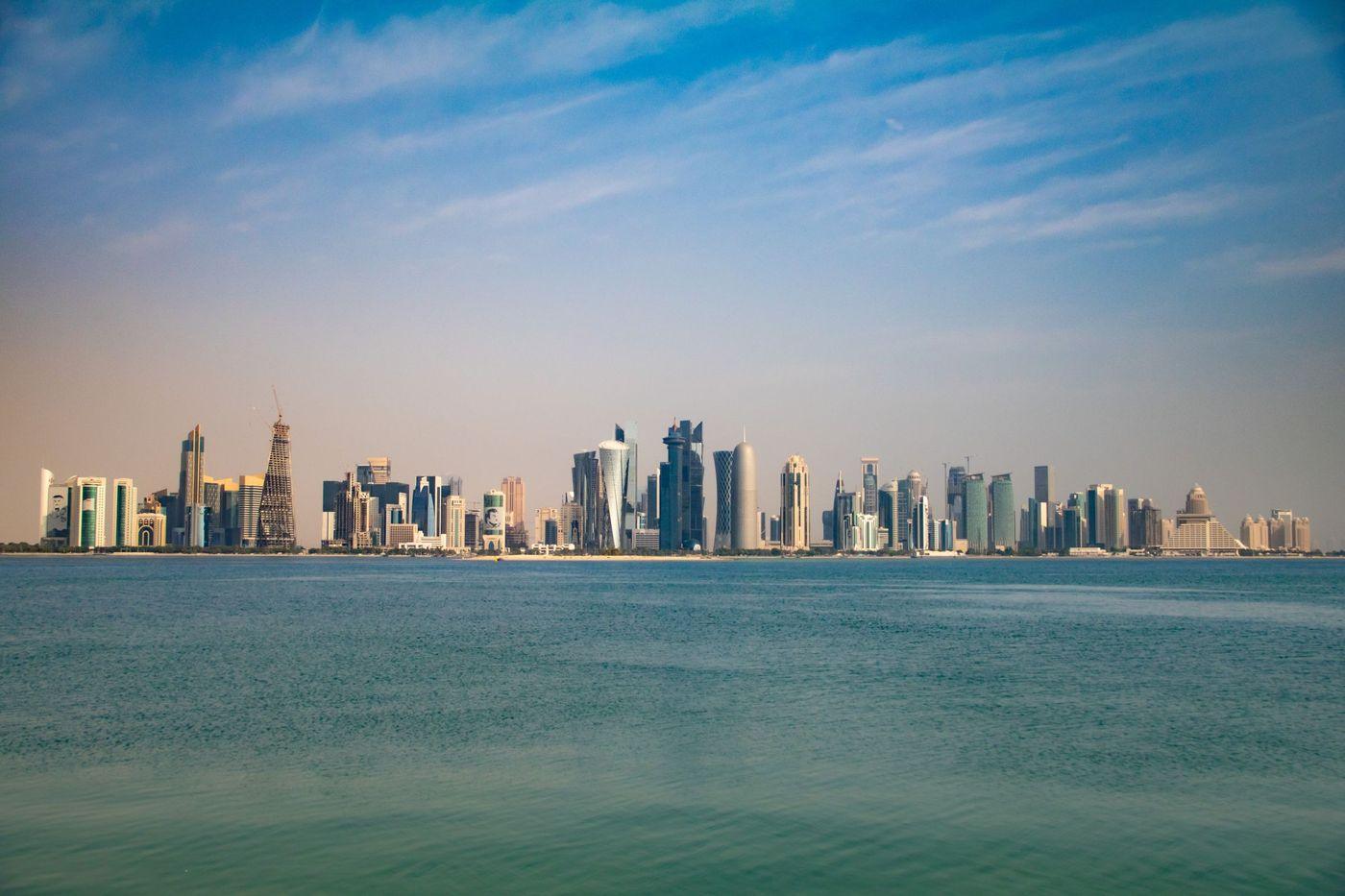 Modern high-rise architecture along Doha's Corniche waterfront under a clear blue sky